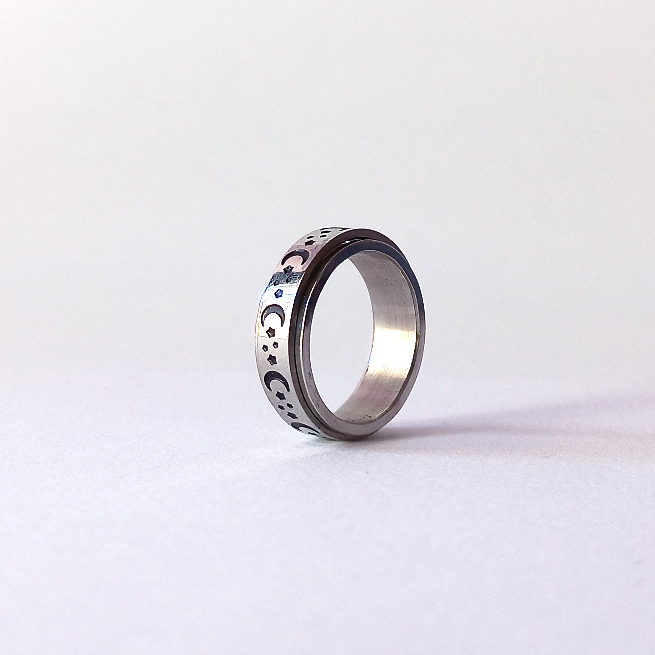 Spinner anxiety ring with engraved spinner. engraves include half moon, stars and small planets.
